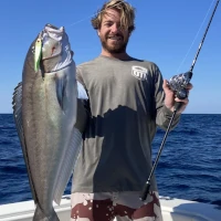 Angler in OTI shirt holding a fish